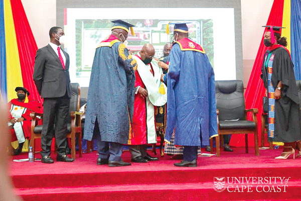 President Akufo-Addo being robed with his academic gown