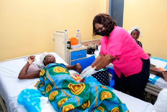 Maame Efua Sekyi-Aidoo Houadjeto, the Deputy National Women’s Organiser of the NDC, giving a gift to one of the patients