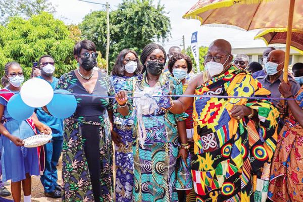 Nana Osei Bosompem III (in Kente), Chief of Jachie and acting President of the Nsuta Traditional Council, cutting the tape to inaugurate the new boys dormitory for the Nsutaman Catholic SHS at Nsuta in the Ashanti Region (above). Pictures: EMMANUEL BAAH