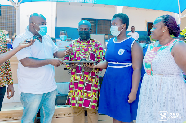 Mr Michael Okyere Kofi Baafi (left) presenting one of the computers to Mr Victor DeGraft Etsison (3rd from right), Municipal Education Director, and one of the female students of the school.