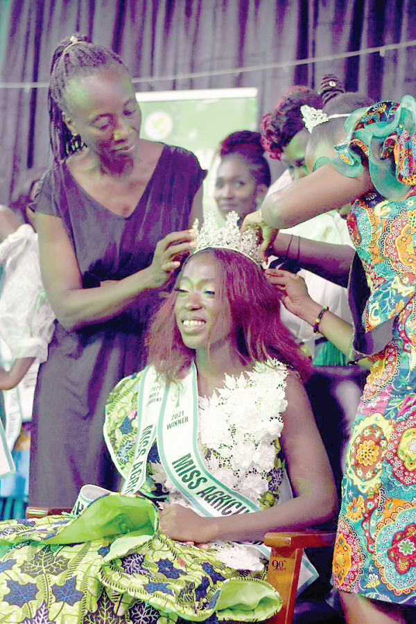 Miss Rendy Abbam (seated), Winner of 2021 Miss Agriculture Ghana, being crowned by Madam Paulina Addy (left), Director of the Women in Agriculture Development Directorate, assisted by Miss Perfect Liz Naa Sackitey (right), Winner of Miss Agriculture Ghana 2020.