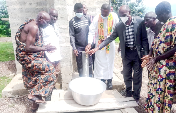 Rev Amoah-Gyasi and opinion leaders of Twifo Eduabeng fetch the first basin of water from the system.