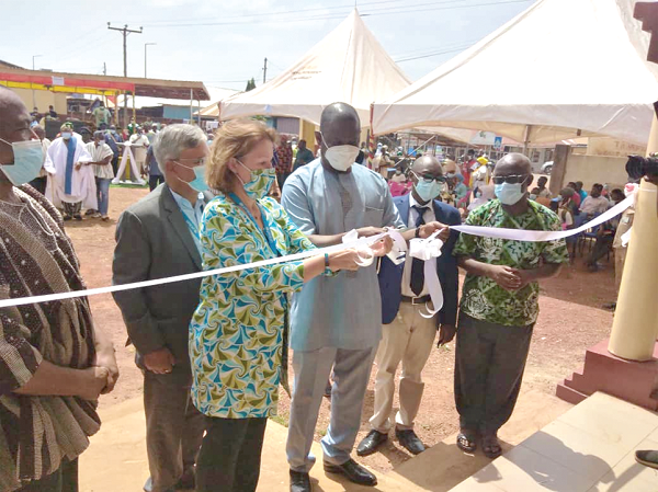 Dr Patrick Kuma-Aboagye (middle), DG of GHS, being assisted by Ms Anne-Claire Dufay, the UNICEF Country Representative, to cut the ribbon.