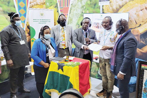  Dr Kwaku Afriyie (3rd from right), Minister of Environment, Science, Technology and Innovation, presenting Ghana's Nationally Determined Contributions document to Dr Henry Kwabena Kokofu (2nd from right), Executive Director of the Environmental Protection Agency, at the Ghana Day event in Glasgow, Scotland