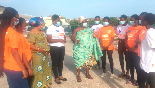 Nana Amba Eyiaba (middle), Krontihemaa of the Oguaa Traditional Area, and Ms Richlove Amamoo (third from left), Central Regional Director of the Department of Gender, interacting with some of the girls