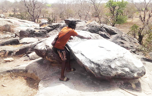 Mr Azumah trying to strike the huge rocks at the entertainment centre with stones to produce various sounds. This is where the slaves danced and sang to entertain themselves