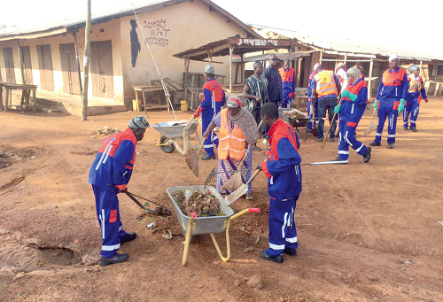 Volunteers and staff of Zoomlion cleaning some open spaces at the Damongo Market
