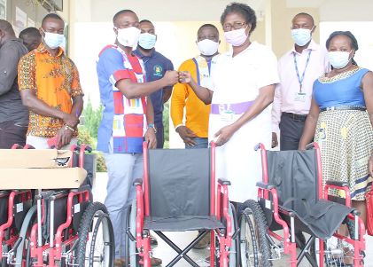 Mr. Emmanuel Yaw Mensah Gokah (2nd from left), President of the Rotary Club of Koforidua - New Juaben, handing over the wheelchairs to the Deputy Director of Nursing Services Dorothy G. Takyi (3rd from right), the Head of the Nursing Administration, while other members of the Rotary Club and staff of the hospital look on