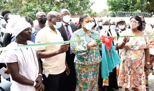 Mrs Rebecca Akufo-Addo (3rd from left) being assisted by Dr Felix Kwame Aveh (2nd from left) and Mrs Elizabeth Sackey (right), Metropolitan Chief Executive of Accra, to cut the tape to commission the hostel facility. With them are Dr Opoku Ware-Ampomah (behind First Lady), CEO, Korle Bu Teaching Hospital, and Nuumo Akassa Diaka II (left), Ga Wulomo. Picture: EBOW HANSON