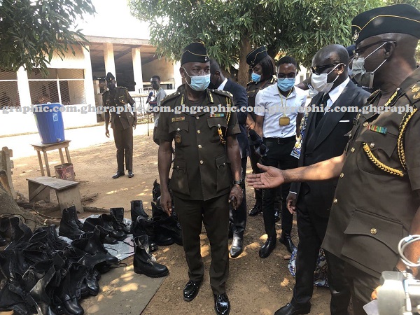 Mr Isaac K. Egyir (right), the Director-General of the Prisons Service, showing Mr Godfred Yeboah Dame  (middle), the A-G, some shoes produced by the inmates of the prison. Picture: EMMANUEL EBO HAWKSON