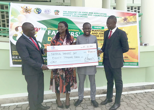  Mr Razak Awudulai (right), Group Chief Executive Officer of Broadspectrum Ghana Limited, presenting a dummy cheque for GH¢80,000 to Mr Yaw Frimpong Addo (left), a Deputy Minister of  Food and Agriculture, while some staff of the company look on