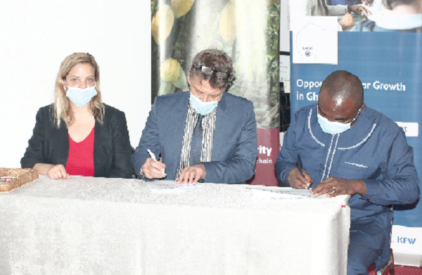Mr Ernest Dwamena (right), Country Manager, Touton Ghana, and Mr Gerald Guskowski (middle), Head of Programme, Special Initiative on Training and Job Creation, GIZ, signing the contract documents. With them is Ms Audrey Lagauche, Global Cocoa Sustainability Manager, Touton Ghana. Picture: Maxwell Ocloo