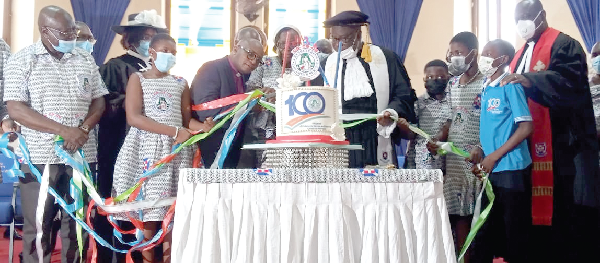 Rt Rev. Prof. Joseph Obiri Yeboah Mante, the Moderator of the PCG,  being assisted by some members of the church to cut the centenary anniversary cake