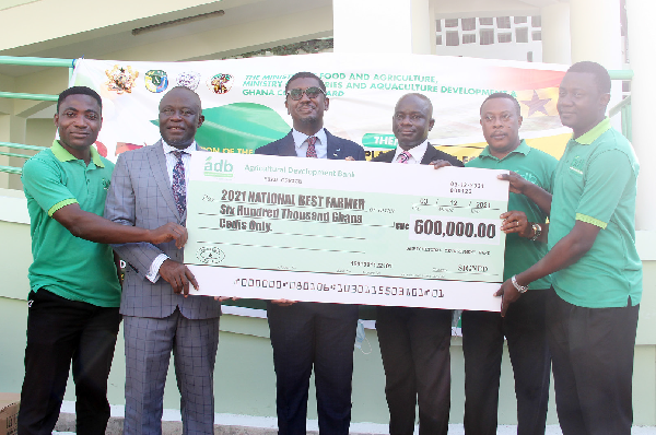 Mr Kwame Asiedu Attrams (3rd from left), General Manager in charge of Agri- Business, ADB, presenting a dummy cheque for the sponsorship of the National Farmers Day celebration to Mr Yaw Frimpong Addo (2nd from left), Deputy Minister of Food and Agriculture