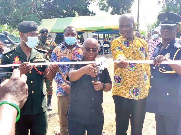 Dr Archibald Yao Letsa, Volta Regional Minister (3rd from left), cutting a tape to commission the project. Those with him are Mr Emmanuel Lumor (2nd from right), Volta/Oti Regional Manager, ECG, and DCOP Edward Oduro Kwateng (right), Volta Regional Police Commander