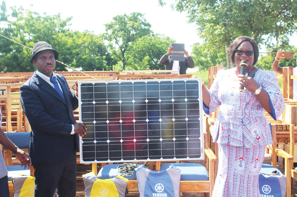 Ms Philippa Larsen (right), President of GNAT, presenting a solar panel to Mr Ahmed Nasir Ibrahim (right), the Sene East District Director of education