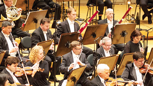 Some members of the Chicago Symphony Orchestra playing their wind instruments during a concert