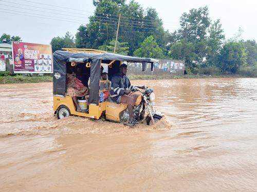 A passenger tricycle (Pragia) wading through the floods at Abura 