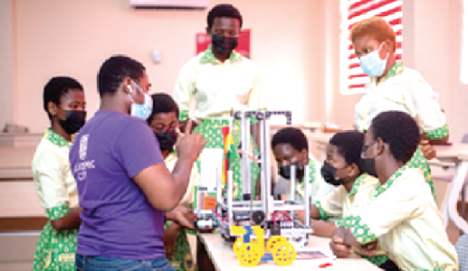   Mentor Benedict Amoako (2nd from left) taking the girls through robotic lessons