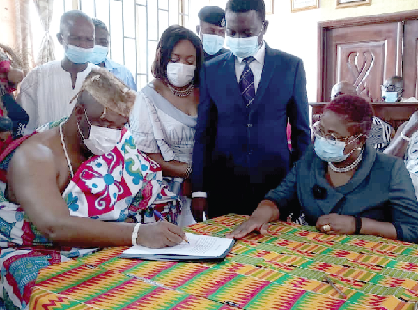 King Tackie Teiko Tsuru II (left), the Ga Mantse, being taken through the signing process by Justice Jane Akweley Lawson-Quaye, a Justice of the High Court 
