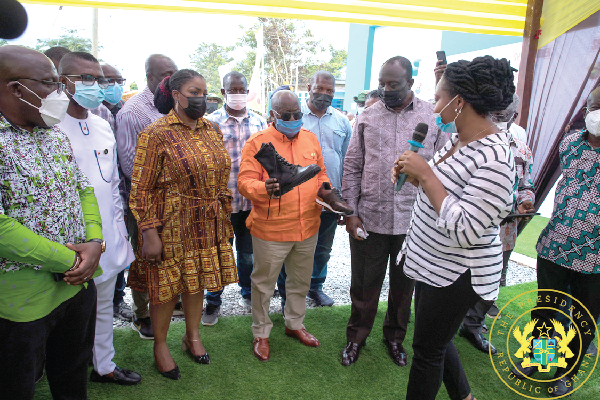 President Akufo-Addo admiring  some products of the shoe factory