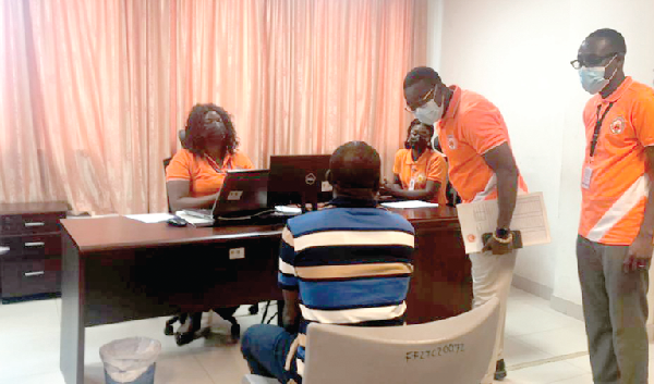 Mr Michael Addotey Addo (2nd right), a Deputy Director-General of SSNIT in charge of Administration and Finance, interacting with a customer after the launch