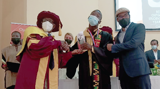 Prof. James Hawkins Ephraim (left), Vice-Chancellor of the Catholic Universityy College of Ghana, presenting the award to Edmond Owusu (middle)