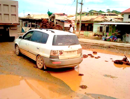 Drivers have no option but drive through puddles of mud due to the numerous potholes