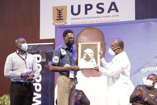 Michael Asante (left), a student of the Opportunities Industralisation Centre Ghana  presenting a portrait to Mr Ken Ofori-Atta, the Minister of Finance, during the event. Picture: EDNA SALVO-KOTEY