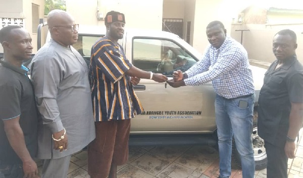 Mr Bernard Mckorley (right) presenting the keys to the car to Nii Ayaafio, (left) with them are some Ga Adangbe Youth