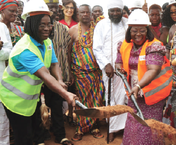 Akosua Frema Osei Opare (right with shovel) cuts sod for the commencement of BSP at Pokuase