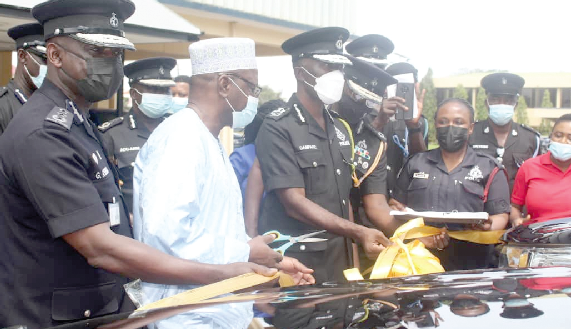 Alhaji Ibrahim Zakari (2nd from left) assisting Dr. George Akuffo Dampare to cut a ribbon before handing over the vehicles