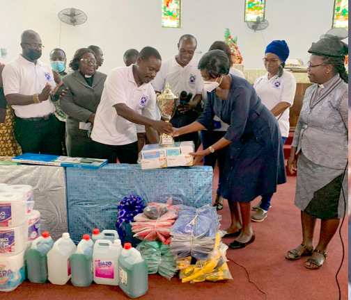 Mr Ebenezer Adotey Adotei, President of the 1986 year group, presenting the items to Mrs Wilhelmina Obuobisa-Atakora, Headmistress of the school