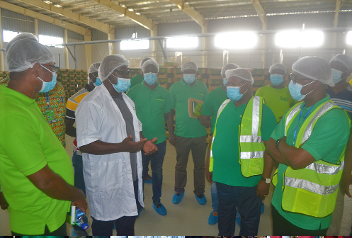  Mr Frederick K. Acquaah (2nd from left),   Director of Operations of the Ekumfi Fruits Factory, explaining a point to Daasebre Agyapong II (right), Dr Kofi Mensah (2nd from right) and other officials during the visit