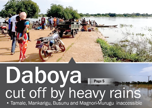 The submerged Busunu-Tachali bridge with some stranded commuters trying to find a way to crossover