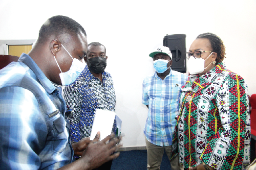 Mr Kester Aburam Korankye (left), a Staff Writer of the Daily Graphic, clarifying an issue with Mrs Mavis Hawa Koomson (right), Minister of Fisheries and Aquaculture  Development, after the press briefing. With them is Mr Kojo Oppong-Nkrumah (2nd left), Minister of Information.