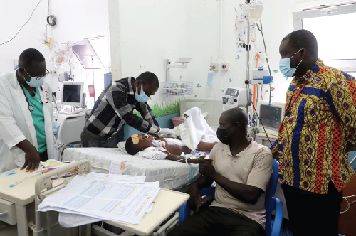 Dr Micheal Amoah (2nd left), Head of the Paediatric Unit, KATH, attending to five-year-old Nborapor after his surgery. Those with them are Mr Martin Sarfo Omari (right), a member of staff of the unit and a sympathiser