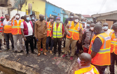 Mr Seth Kwame Acheampong (arrowed), Eastern Regional Minister, in the company of Ms Victoria Adu (6th left), the Municipal Chief Executive for Birim Central, and other officials inspecting some of the burnt structures at the Oda Central Market. Picture: SAMUEL KYEI BAOTENG