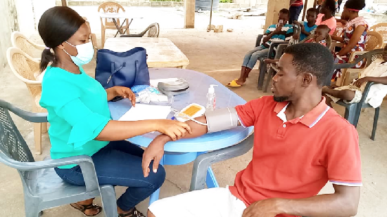A community member (right) being attended to by a health professional during the health screening exercise