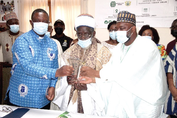 Dr Cyril Fayose (left), Secretary-General  of the Christian Council of Ghana, and Sheikh Ali Abubakar Napari (right), Ceo of the Light Foundation, presenting a citation to Sheikh Osman Nuhu Sharubutu (middle), the National Chief Imam of Ghana. Picture: ESTHER ADJEI 