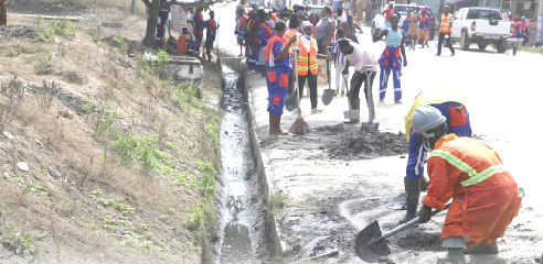 Participants in the Graphic/Zoomlion cleanup exercise clearing a gutter in Cape Coast