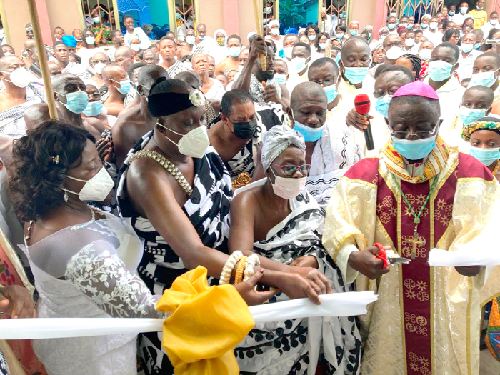 Nana Otuo Siriboe II (2nd left), the Juabenhene and Nana Akosua Akyiamaa II (2nd right) the Juabenhemaa, being assisted by Most Rev. Osei-Bonsu (right) to cut the tape to inaugurate the new Sunday school chapel for the St Stephen’s Catholic Church at Juaben in the Ashanti Region