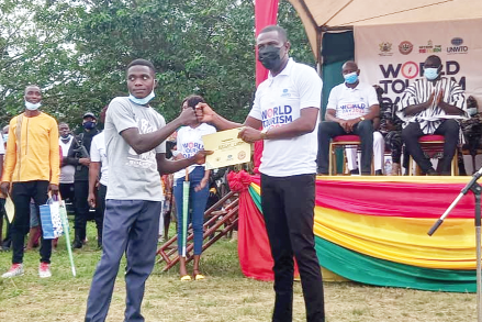 Master Bright Lartey, the winner, receiving his prize from Mr. Okraku Mantey, Deputy Tourism Minister