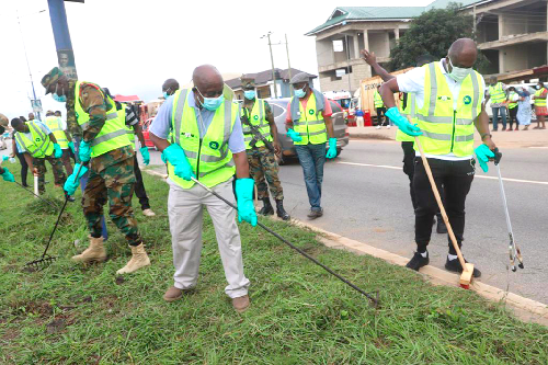 Mr Simon Osei Mensah (middle), the Ashanti Regional Minister, joined by Lt Col Godfred Asampong (left), the Commanding Officer, Central Command of the Ghana Armed Forces, to sweep portions of the Kumasi-Accra road at Ejisu in the Ashanti Region, during the clean-up exercise. With them is Nana Yaw Wiredu (right), a member of the committee on sanitation. Picture: EMMANUEL BAAH