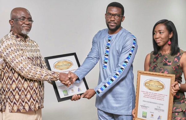 Randy Attuquaye Clottey  (middle), Finacial Controller, joined by Maame Ama Asantewaa Adjem, Sales and Marketing, both of Golden Beam, to receive the award from Jermaine Nkrumah, CEO of DNT