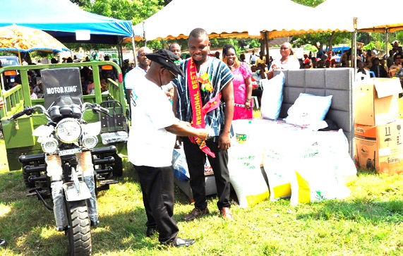 Dr Archibald Yao Letsa (left), the Volta Regional Minister, decorating Vozbeth Kofi Azumah, the Regional Best Farmer, with a sash after presenting his prize to him
