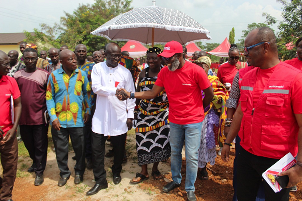 Robert Dwomor Mensah (2nd from left), DCE for Asutifi South, thanking John Nkaw, ActionAid Ghana Country Director, after the handover of the classroom block to the community. Those in the picture are officials from ActionAid and members of the community. 