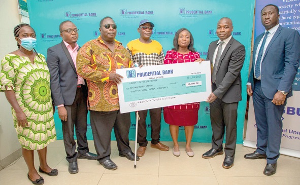 Frederick Adomako-Ansah (2nd from right), Head of Commercial Banking, Prudential Bank, presenting the dummy cheque to the officials of the union