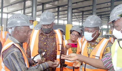 Michael Paid Tuwor (left), MD, Accra Compost and Recycling Plant, speaking with Dan Botwe (middle), Minister for Local Government, Decentralisation and Rural Development, at the compost. With them are some staff from the ministry