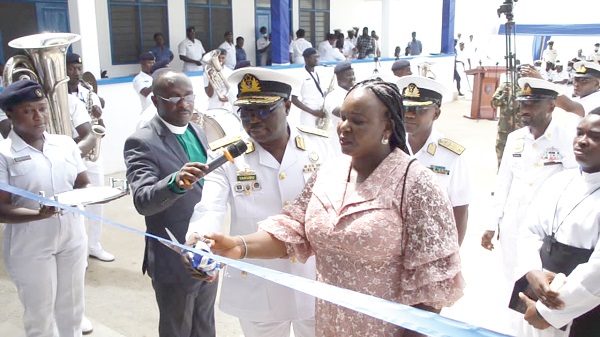 Rear Admiral Issah Adam Yakubu, the Chief of Naval Staff, being assisted by Nana Adwoa Owiaba Bedu-Addo, wife of Capt. Bedu-Addo, to cut the tape to inaugurate the facility